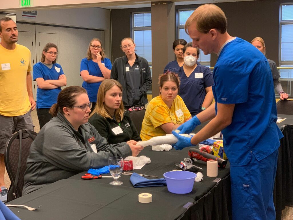 doctor showing how to wrap gauze to a group of onlookers